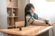 A woman sitting at a desk in a classroom.