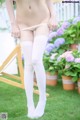 A woman wearing white stockings standing in the grass.