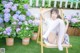 A woman sitting on a chair in front of a bunch of flowers.