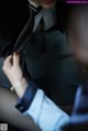 A woman in a suit and tie sitting in a car.