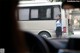 A woman standing in front of a white bus.