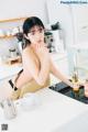 A woman sitting at a kitchen counter with a cup of coffee.