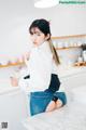 a woman sitting on top of a counter in a kitchen