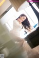 A woman in a white suit sitting at a piano.