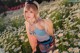 A woman in a field of daisies posing for a picture.