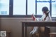 A woman sitting at a table reading a book.