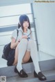 A woman sitting on the steps of a building with a backpack.