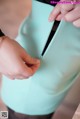 A woman holding a mint green purse with a zipper.