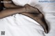 A woman's legs in black stockings laying on a bed.