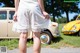 A woman standing in front of a yellow car.