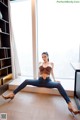 A woman sitting on a window sill in a room.