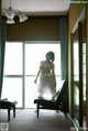 A naked woman standing in front of a window in a room.