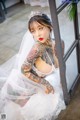 A woman in a wedding dress with tattoos on her body.