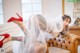 A woman in a wedding dress and red high heels sitting on a couch.