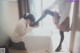 A woman putting on a pair of shoes on a table.