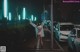 A woman standing in the middle of a street at night.