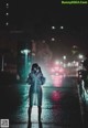 A woman wearing a face mask standing in the middle of a street at night.