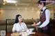 A waitress serving food to a woman at a restaurant.