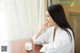 A woman sitting at a table with a glass of milk.